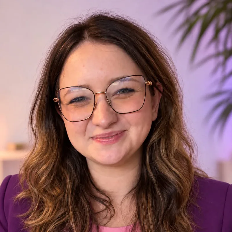 Karolina Michta, uśmiechnięta, w okularach i fioletowej marynarce